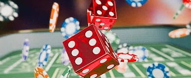 Würfel und Chips fallen auf eine Spielfläche.