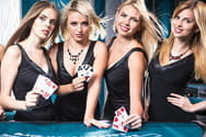 Vier weibliche Croupiers stehen am Casinotisch.