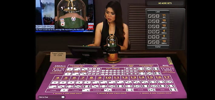 Live Sic Bo von Playtech im Live Bereich des Ladbrokes Casinos. Der Dealer überprüft auf einem Bildschirm, der sich vor ihm auf dem Spieltisch befindet, das Ergebnis der letzten Spielrunde.