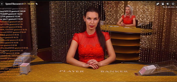 Live Speed Baccarat von Evolution Gaming im Live Bereich vom Mega Casino. Während der Dealer auf die Einsätze wartet, werden links die Gewinner des letzten Spiels angezeigt. Im Hintergrund ist ein weiterer Spieltisch zu erkennen.