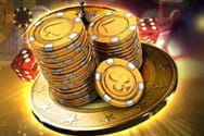 ALT: Goldene Spielchips auf einem Stapel, daneben Würfel und ein Roulette-Rad.