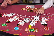 Das Bild zeigt das Video Tischspiel Blackjack, bei dem der Spieler vier Karten aufgenommen hat und die Bank bisher zwei. Der Spieler warten nun, bis die Bank ihre nächste Karte legt