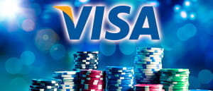 Im Hintergrund ist ein Münzstapel und im Vordergrund das Logo von Visa sowie dem Casino Anbieter Karamba zu sehen.