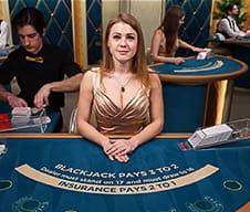 Eine gut aussehende Dealerin sitzt an einem Blackjacktisch