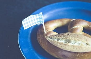Das Bild zeigt eine Brezel mit einer bayerischen Landesflagge.