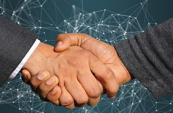 Ein Handshake besiegelt die Fusion.