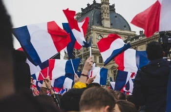 Französische Flaggen werden geschwenkt.