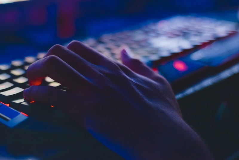 Eine Hand an einer Tastatur.