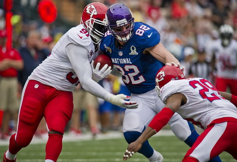 Drei NFL-Spieler im Kampf um den Football.