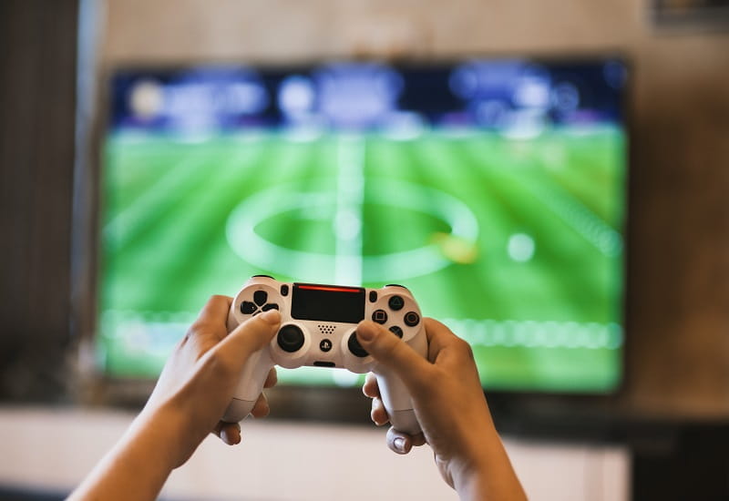 Ein Playstation-Pad in den Händen eines Fifa-Spielers.