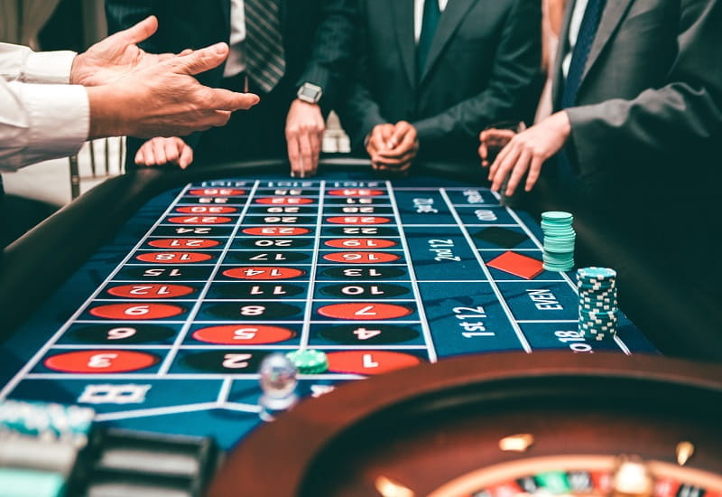 Spielbankbesucher an einem Roulette-Tisch.