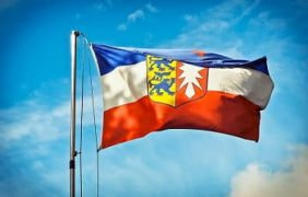 Die Fahne Schleswig-Holsteins im Wind.