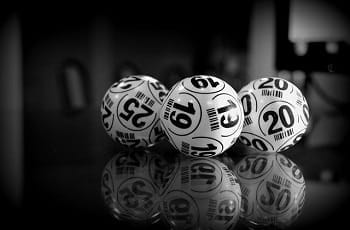 Weiße Lottobälle auf einem Glastisch.