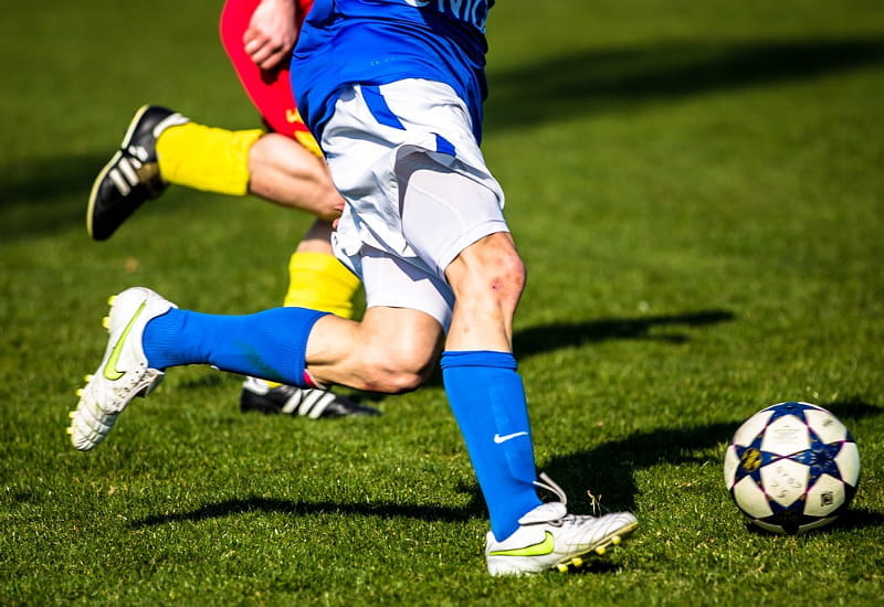 Zwei Fußballspieler kämpfen um den Ball.