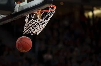 Ein Basketball fliegt durch den Korb.