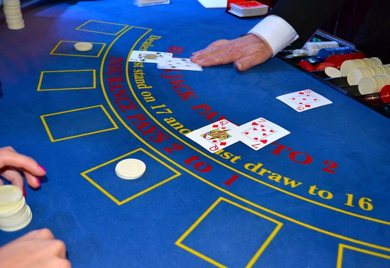 Ein Casino-Dealer deckt Karten beim Blackjack auf.