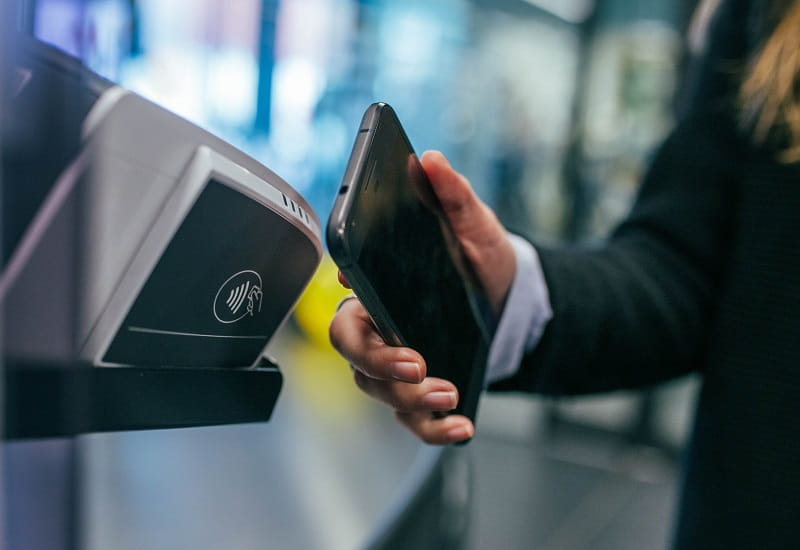 Eine Zahlung wird per Smartphone an einem Scanner durchgeführt.
