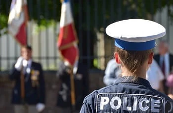 Eine französische Polizistin und französische Nationalflaggen.