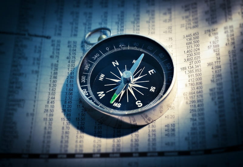 Ein Kompass liegt auf einer Finanzübersicht.