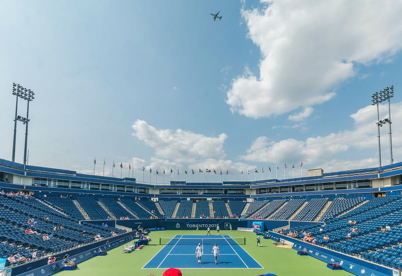 Zwei Tennisspieler auf dem Court eines Stadions.