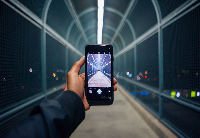Eine Person fotografiert einen Gang mit dem Smartphone.