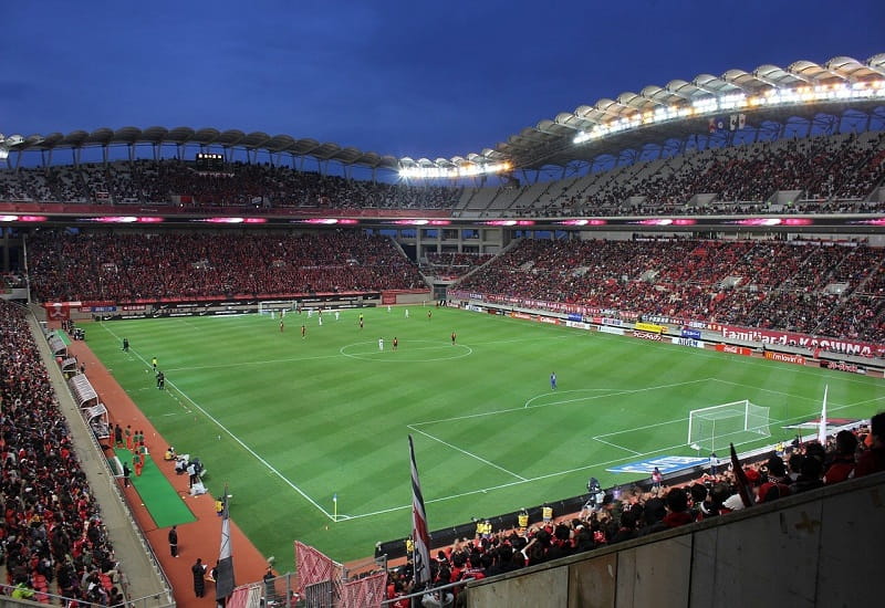 Ein gefülltes Fußballstadion während eines Spiels.