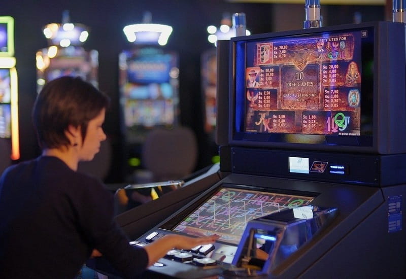 Eine Spielerin vor einem herkömmlichen Spielautomaten.