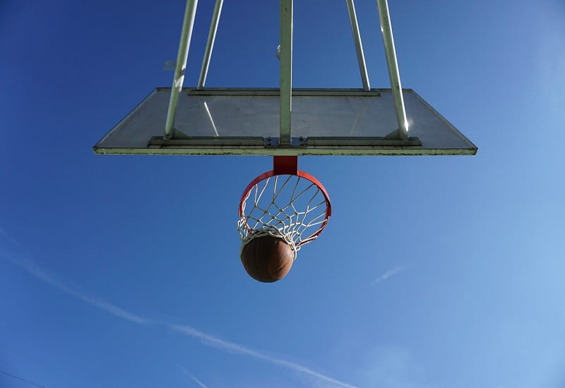 Ein Basketball fliegt durch einen Korb.