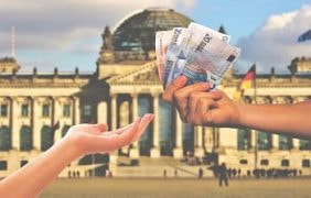 Geldscheine werden vor dem Berliner Bundestag überreicht.