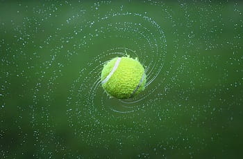 Ein nasser rotierender Tennisball.