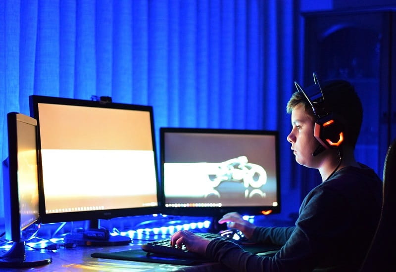Ein Jugendlicher mit Headset sitzt am PC.