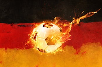 Ein brennender Fußball vor einer deutschen Flagge.