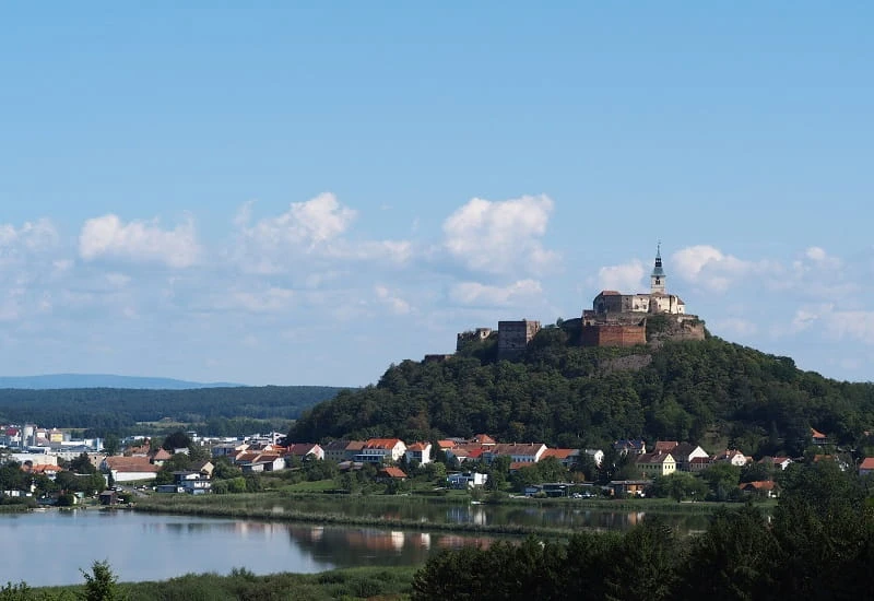 Eine Burg über einem Dorf am See im Burgenland.