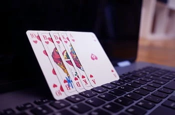 Spielkarten lehnen an einem Laptopbildschirm.