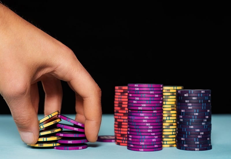 Eine Spielerhand platziert Pokerchips.