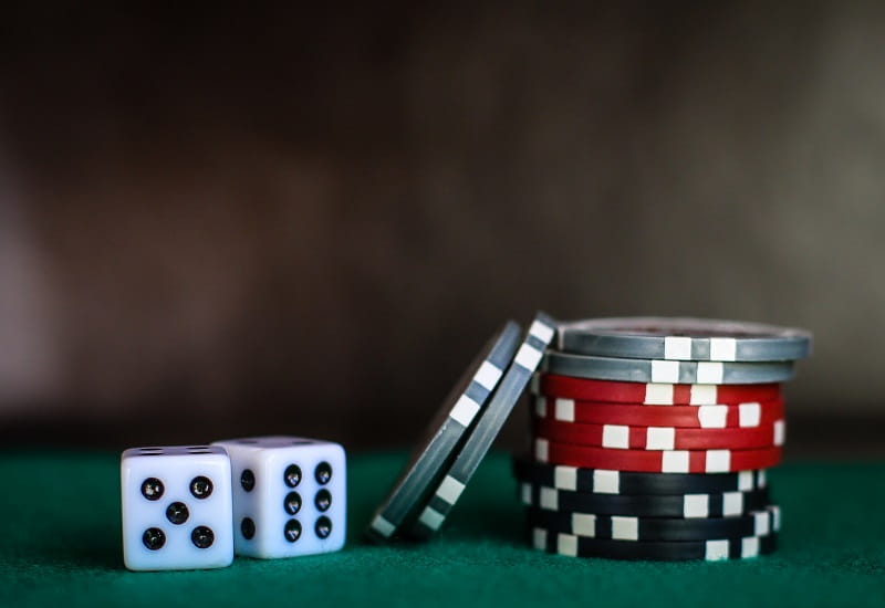Spielchips und Würfel auf einer Tischfläche.