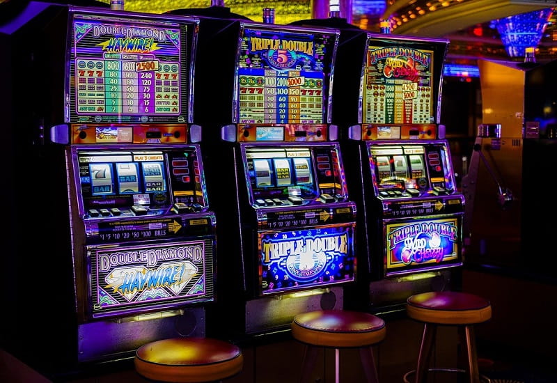 Drei Spielautomaten in einem Casino.