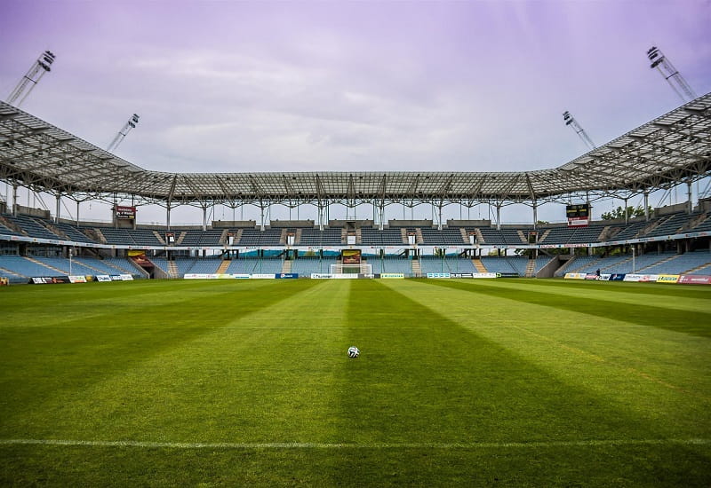 Ein Fußball auf dem Spielfeld eines leeren Stadions.