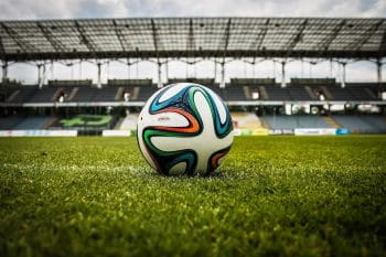 Ein Fußball auf Rasen in einem Fußballstadion.