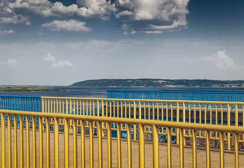 Geländer in den Farben der Ukraine an einem See.