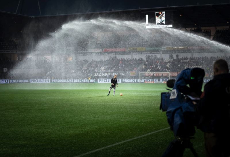 Fußballspieler in einem Stadion bei Flutlicht.