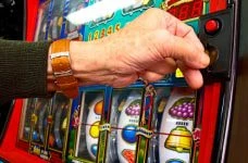 Ein Mensch vor einem Spielautomaten in einem Casino.