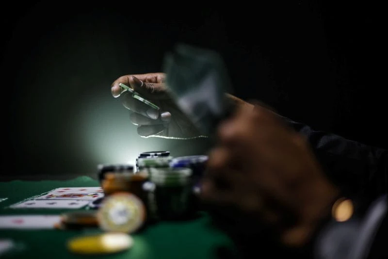 Pria bermain poker di turnamen dengan lampu sorot yang bagus.