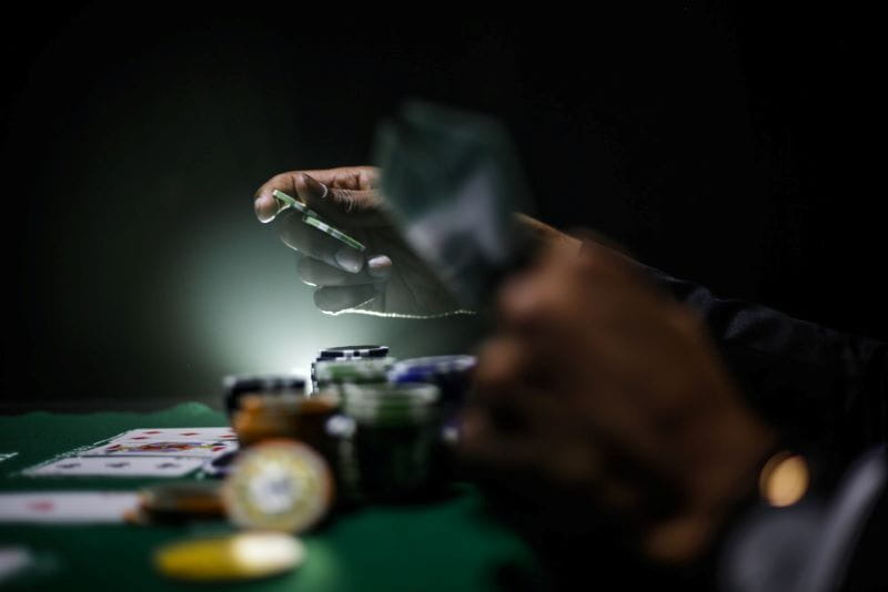Mann spielt Poker bei Turnier mit gutem Spot Light.