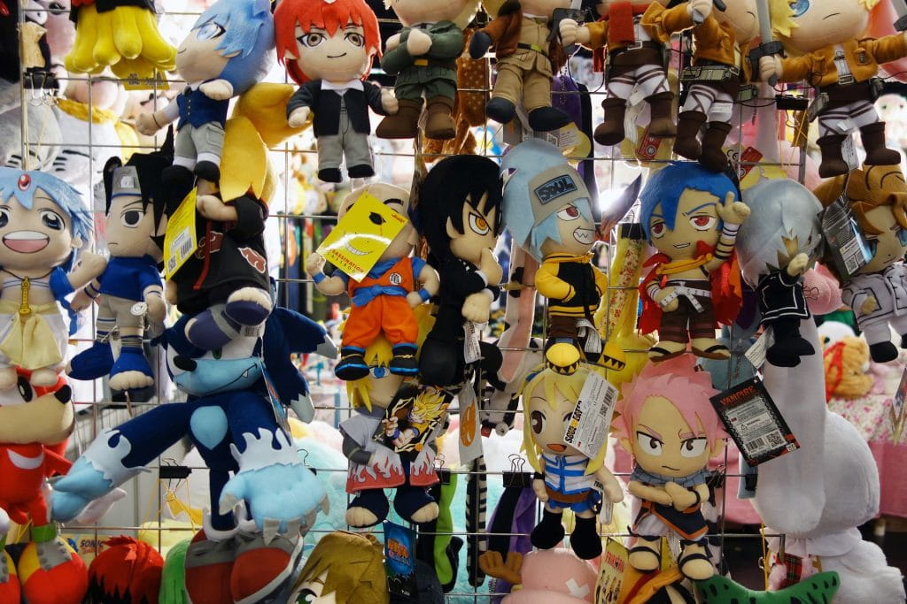 Mangaspielfiguren hängen an einem Verkaufsstand.