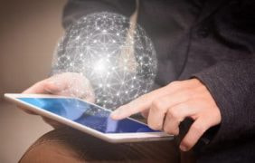 Unter einem Sicherheit-Schriftzug sitzt ein Mann an einem Laptop.