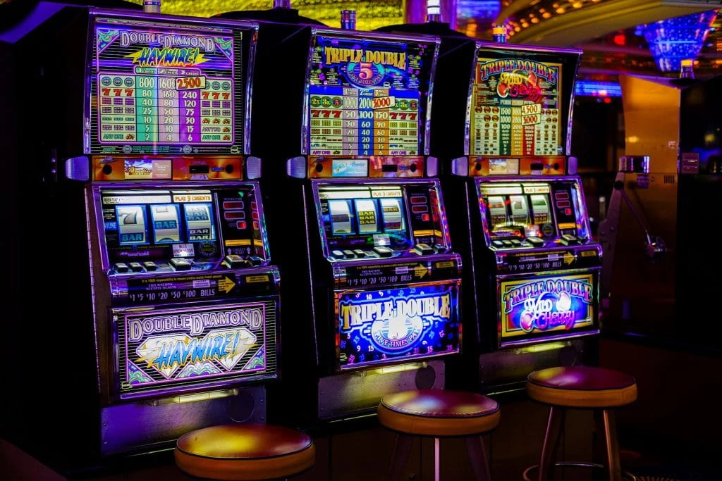 Drei verschiedene Spieleautomaten sind in einem Casino aufgebaut.
