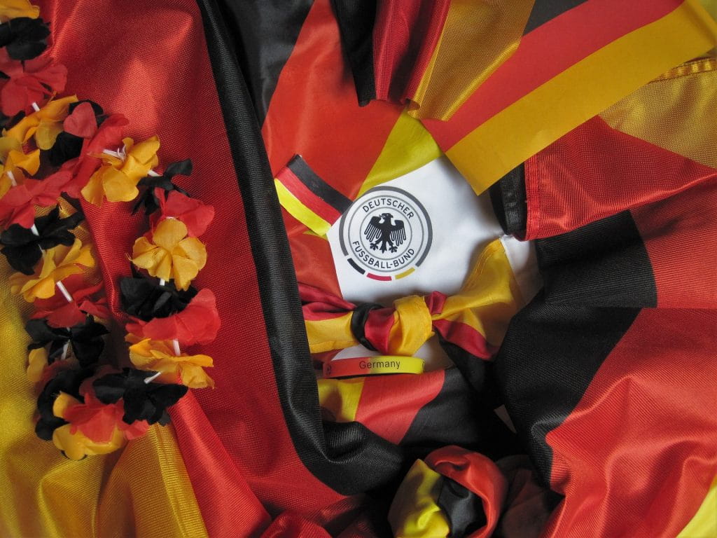 Accessoires in Schwarz-Rot-Gold umrahmen das Logo des DFB.