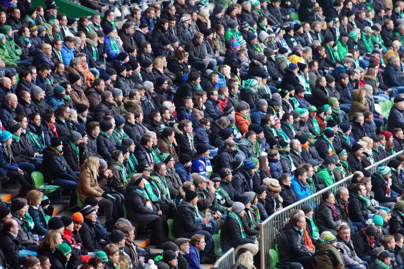 Fans des SV Werder Bremen verfolgen ein Fußballspiel.