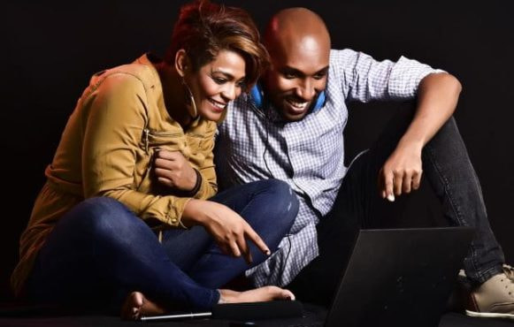 Ein Pärchen schaut gemeinsam etwas auf einem Laptop an.